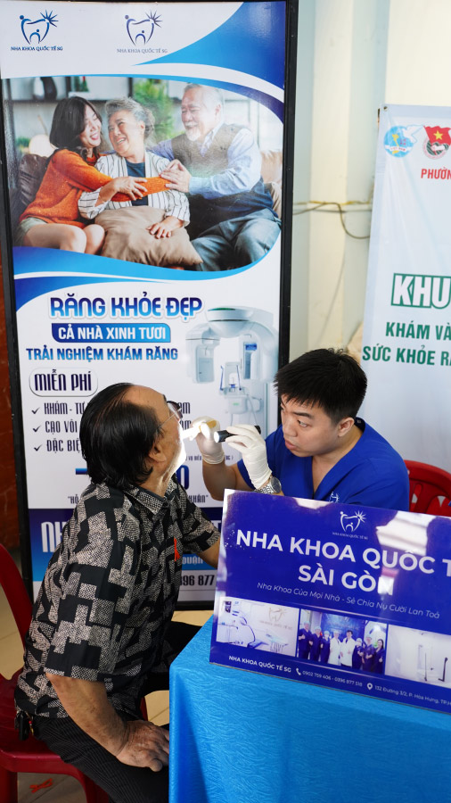 Bác sĩ tại Nha Khoa Quốc Tế SG thăm khám răng miệng bệnh nhân lớn tuổi
